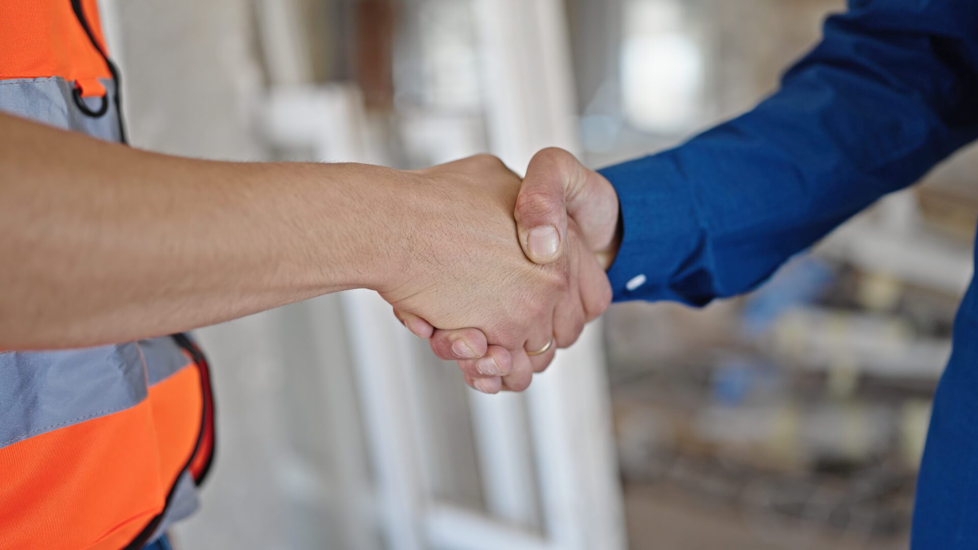 A close up of two men shaking their hands 